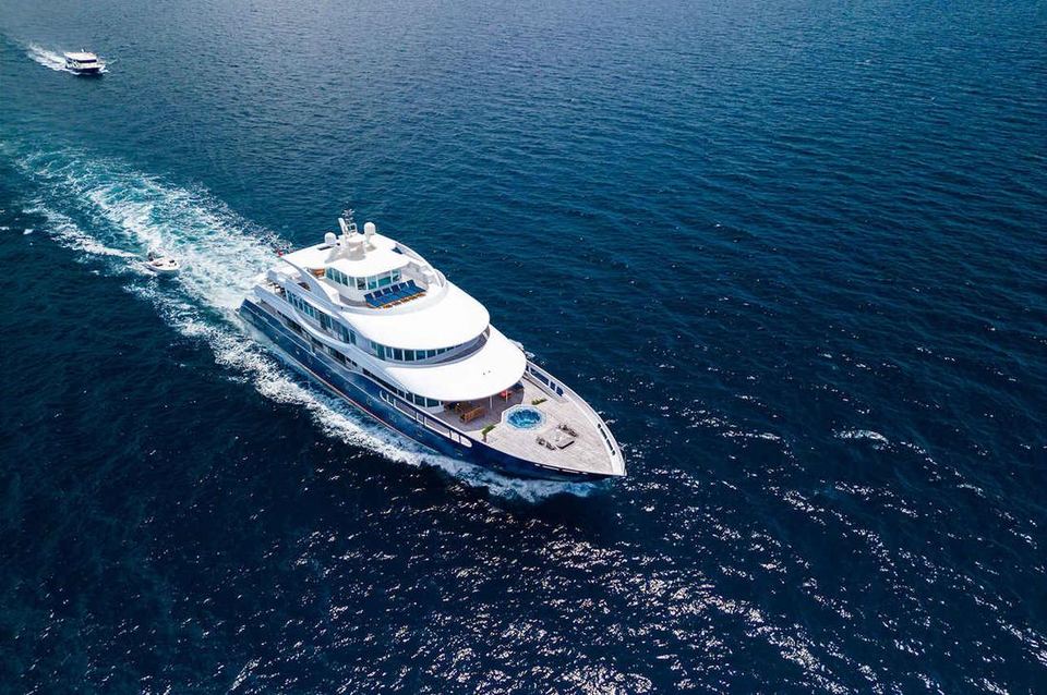 Under way between atolls: Crossing open water with the hot tub out on the foredeck and the dive dhoni following behind.